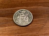 Reverse of 1969 Canadian 50 cent coin showing coat of arms and denomination