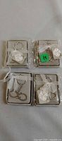 Four boxed infinity "love" keychains, three sealed, one open