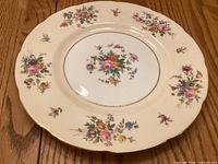 Front view of Minton Sherwood dinner plate showing floral pattern, central bouquet, scalloped gilt rim.