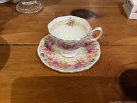 Cup and saucer set on wooden surface showing pattern and condition