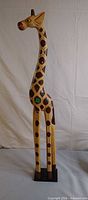 Front view of tall wooden giraffe sculpture