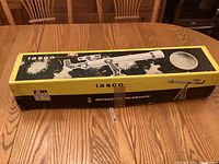 Top view of closed yellow Tasco box showing telescope graphics