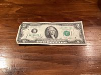 Front of US $2 bill showing serial number, seal, and condition