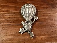 Front view of pewter hot-air balloon brooch with stars
