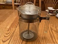 Side view of assembled glass percolator showing handle and lid