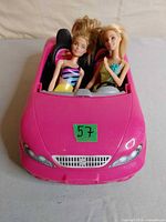 Front view of pink Barbie convertible with two dolls seated