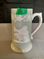 Full view of mug front showing grapevine relief band, seated figure scene, handle