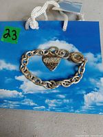 Front view of silver-tone Guess bracelet showing chain, clasp and heart charm