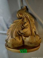 Front view showing swirling acanthus leaf design and gold finish
