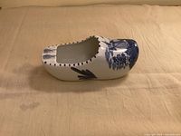 Left side view of blue and white ceramic clog ashtray