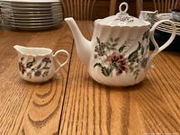 Teapot and creamer side by side showing pattern and scale