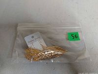 Earrings on card inside zip bag showing leaf design and gold tone finish