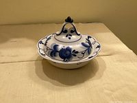 Covered porcelain butter dish showcasing overall form and decoration