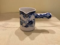 Front view showing floral pattern, spout and handle base