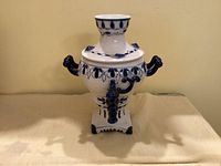 Front view of Gzhel porcelain samovar showing handles, pedestal base and painted design