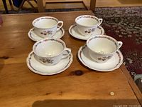 Four teacups on matching saucers displayed on table