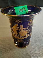 Front view showing cobalt glaze, gold courting scene and pedestal form