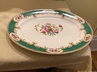 Top view of oval platter showing floral centre, green border and gold detailing