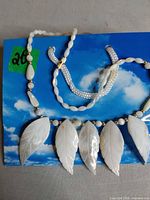 Full view of necklace showing bead pattern and five leaf pendants