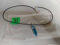 Full view of necklace and blue crystal pendant