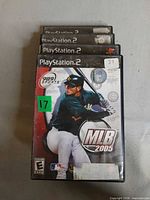 Stacked PlayStation 2 game cases showing MLB 2005 on top