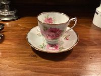 Cup on saucer showing floral pattern and gold trim