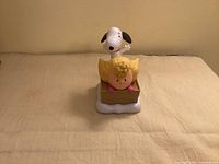Front view of Snoopy and Sally sledding figurine