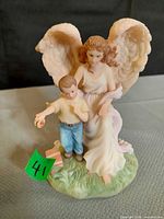 Front view of Seraphim Classics angel figurine with boy