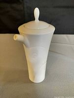 Front view of white Wedgwood lidded jug showing side spout and relief detail