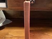 Spine of red cloth hardcover showing wear