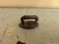 top view of miniature cast iron sad iron showing handle and oval body