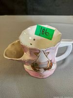 Front view of ceramic tea strainer cup showing pink band with sailboat and integrated strainer spout