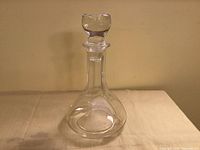 Full view of clear glass decanter with stopper