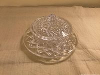 Round clear crystal butter dish with dome lid showing diamond pattern and knob