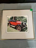 Framed and matted photograph print of red vintage roadster car in silver frame