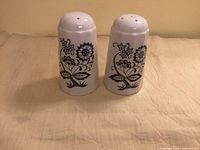 Front view of both ceramic shakers showing floral blue pattern