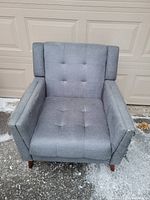 Front view of grey tufted armchair showing seat and back