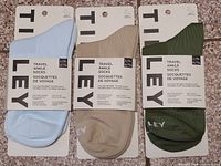 Three pairs of Tilley travel ankle socks in packaging, colours light blue, tan, olive