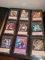 Open binder showing nine Yu-Gi-Oh cards in 9-pocket page