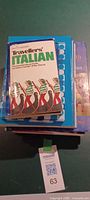 Stack of Italian language books topped by Travellers' Italian phrasebook