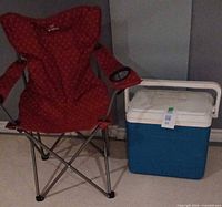 Outbound red folding camp chair and blue-white cooler side by side