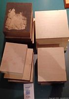 Stack of square and rectangular cradleboards showing unfinished and painted faces