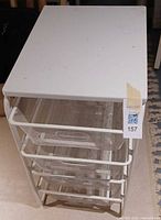 Full view of Ikea white wire four-drawer unit, wood top