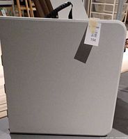 Table folded with carry handle visible and lot tag applied