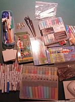 Overview of lot showing markers, paint sets, pastels, crayons, punch, Cricut tools