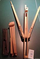 Folded Mont Marte standing easel on right, detachable wooden shelf center, Artist's Loft black tabletop easel left