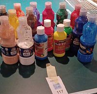 Front view showing all sixteen paint bottles with labels and caps visible