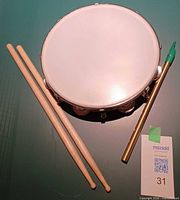 Tambourine top, pair of drumsticks, brass tin whistle