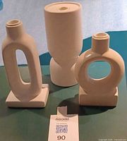 Front view of three matte white ceramic candle holders