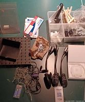 Overview of lot showing flyer holders, receipt books, pegboard shelf, fairy lights, plastic tray, hooks, chains, easels, LuminoLite lights, Square box